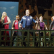 The faux, cheaply costumed Avengers of the Rogers musical sing at the audience from the street set-level.